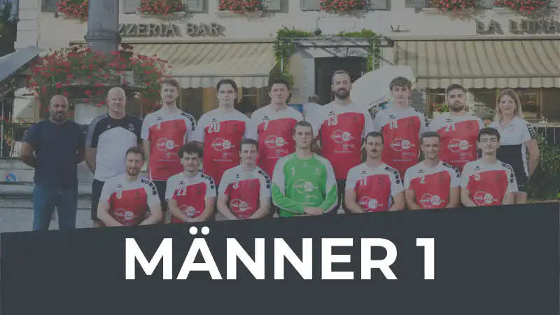 Group shot of a men's sports team in red and white jerseys posing outdoors in front of a cafe; goalkeeper in green stands center.